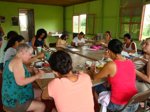 Explore & Create group participating in a round robin painting exercise with painting group Corazones Valientes