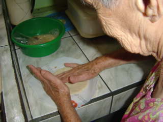 Hortensia in her Atenas, Costa Rica kitchen forming a tortilla with her hands